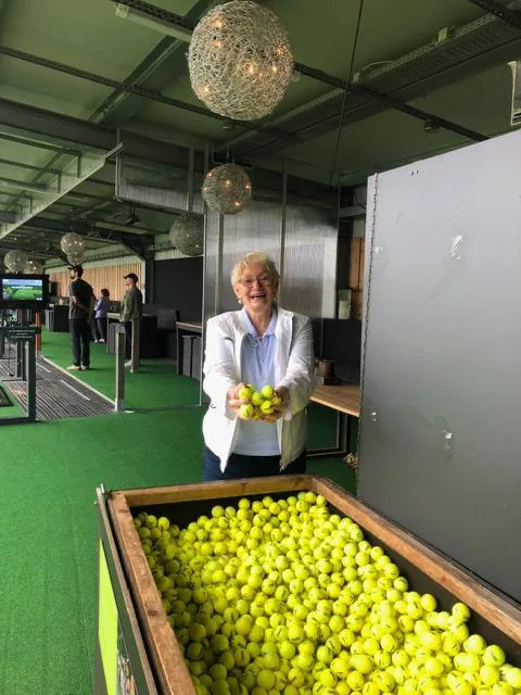 Teilnehmerin mit Golfbällen auf der Driving Range beim inklusiven Golf-Event