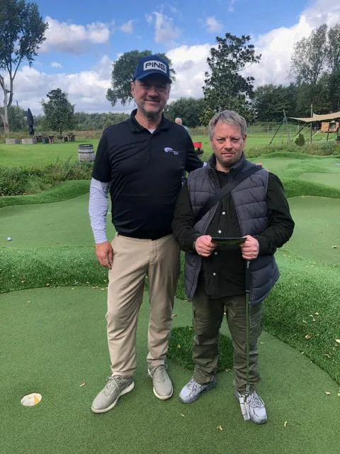 Golflehrer und Teilnehmer auf dem Putting-Grün beim inklusiven Golf-Event