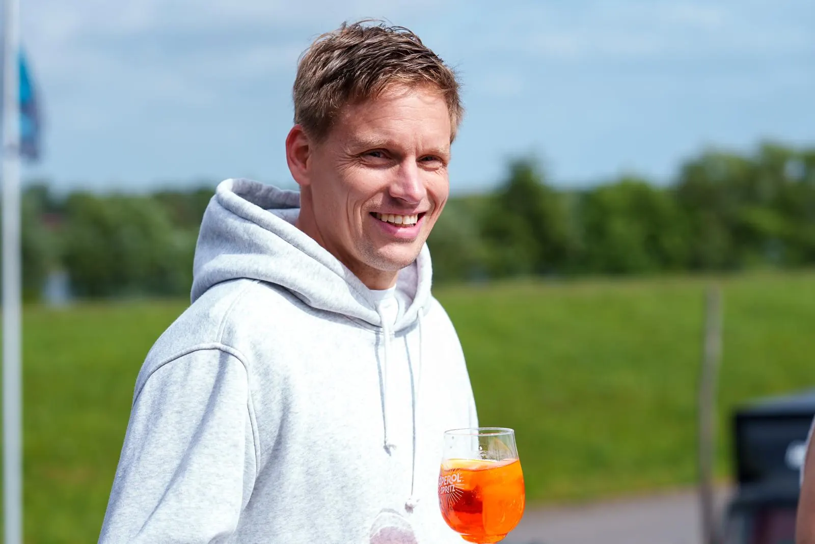 Lächelnder Gast mit Aperitif auf dem Deich