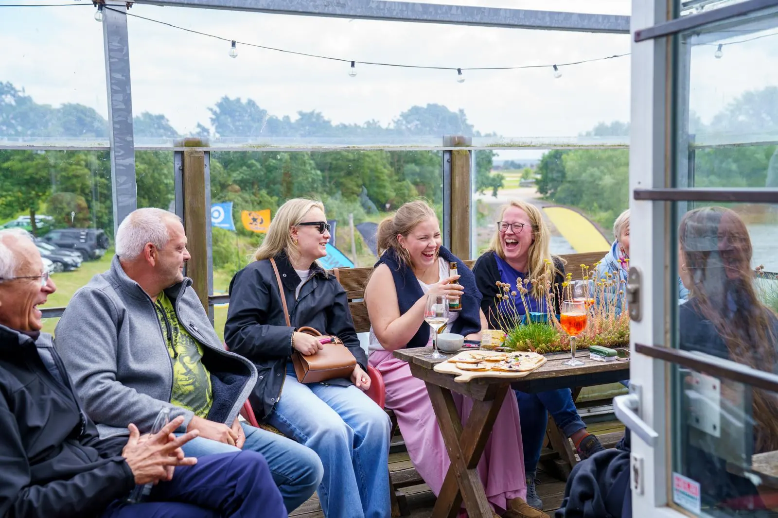Lachende Gäste an der Terrasse der Wassersportstation an der Dove-Elbe