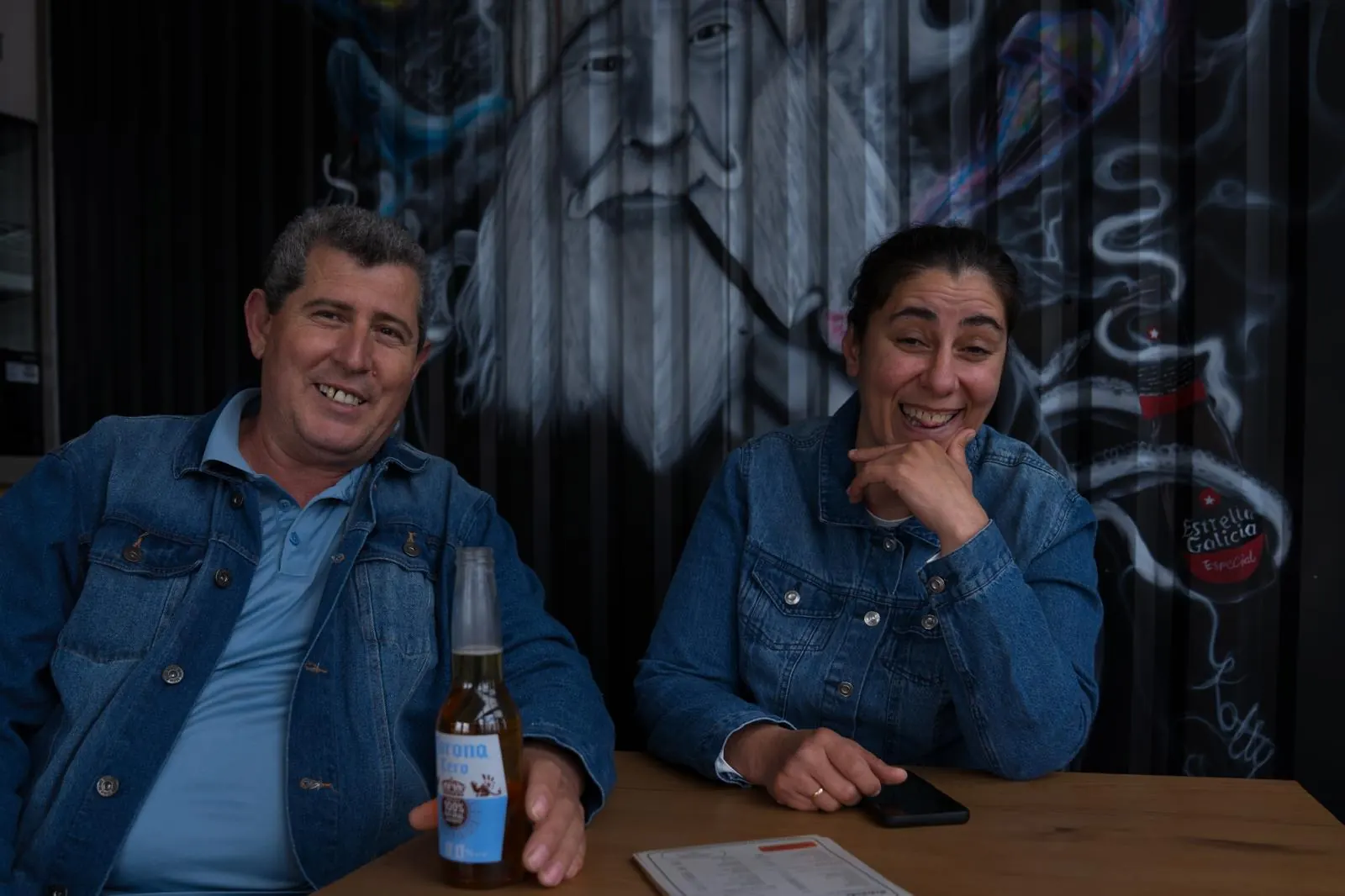 Zwei Gäste am Tisch vor der Graffiti-Wand der Station