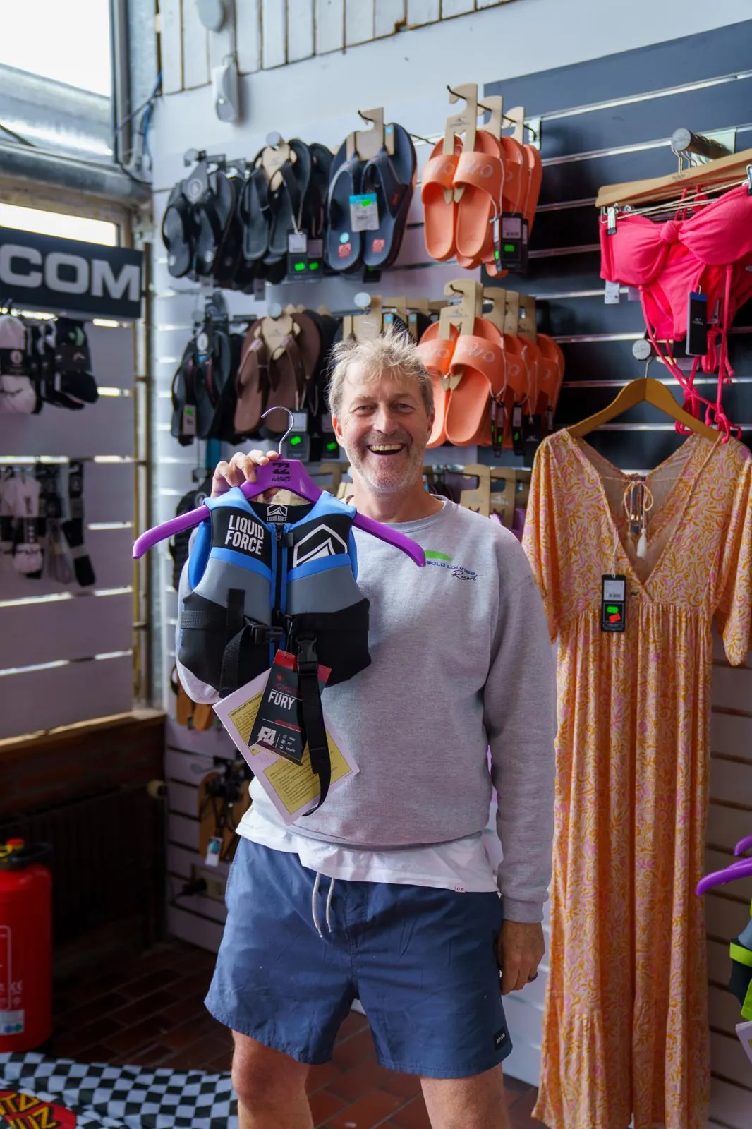 Lächelnder Gast präsentiert eine Schwimmweste im Shop