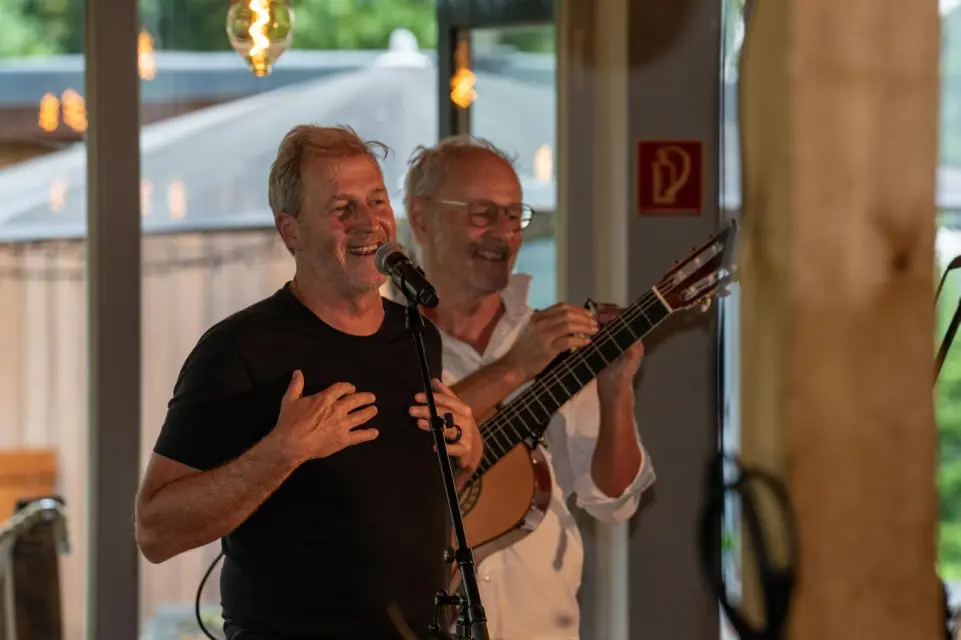 Zwei Musiker beim gemeinsamen Auftritt in der Elb-Lodge, Gesang und Gitarre