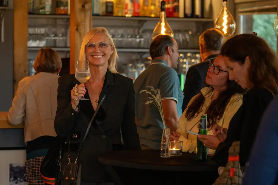 Gäste in bester Laune an der Bar der Elb-Lodge