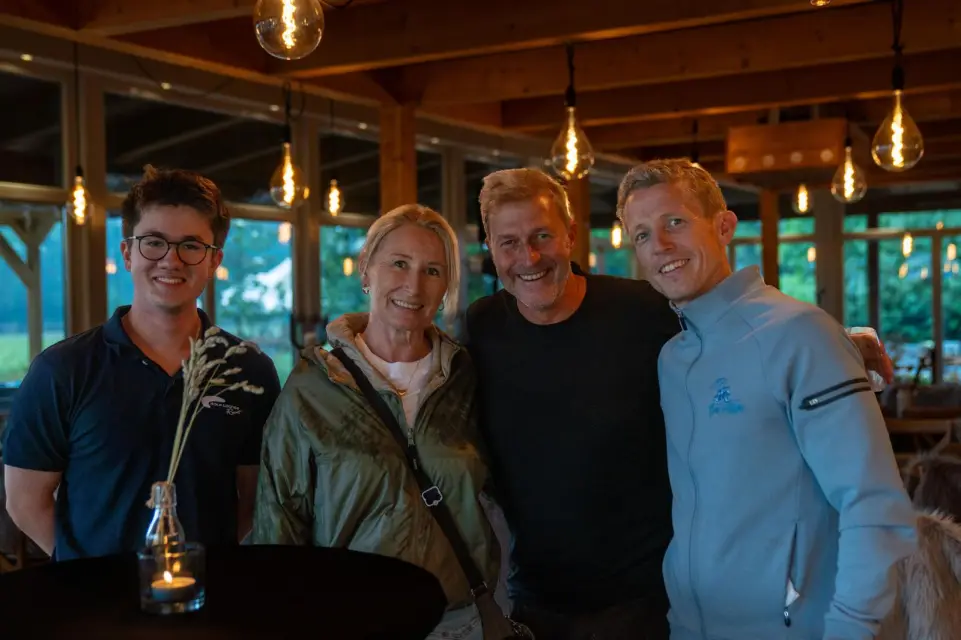 Vier Gäste beisammen in der warm beleuchteten Elb-Lodge