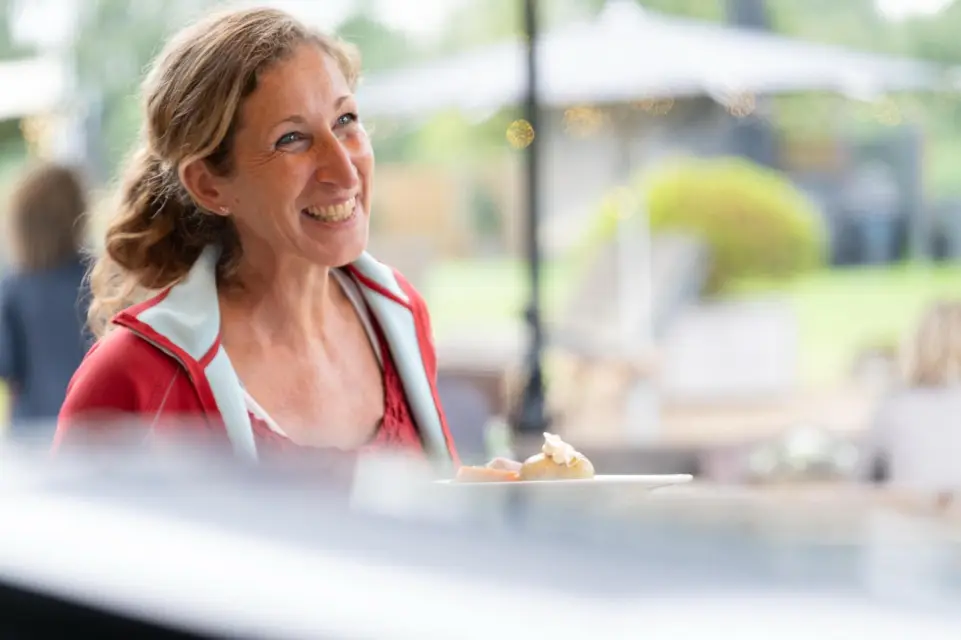Lachende Besucherin mit Teller beim Sommer-BBQ