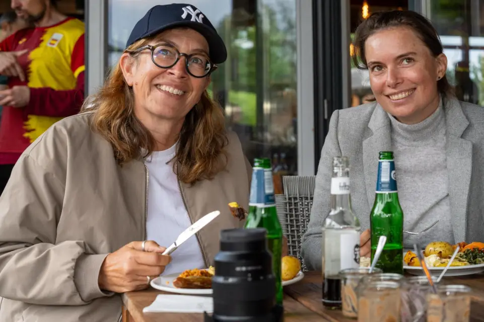 Zwei Besucherinnen genießen das BBQ-Buffet am Tisch